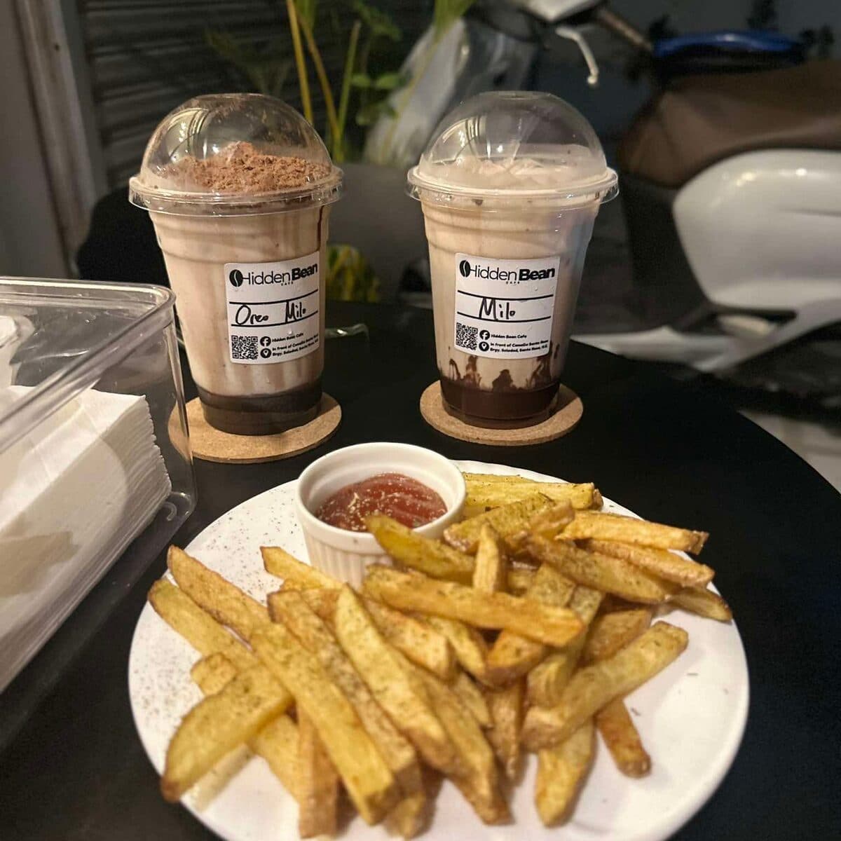 Two iced drinks beside a plate of fries