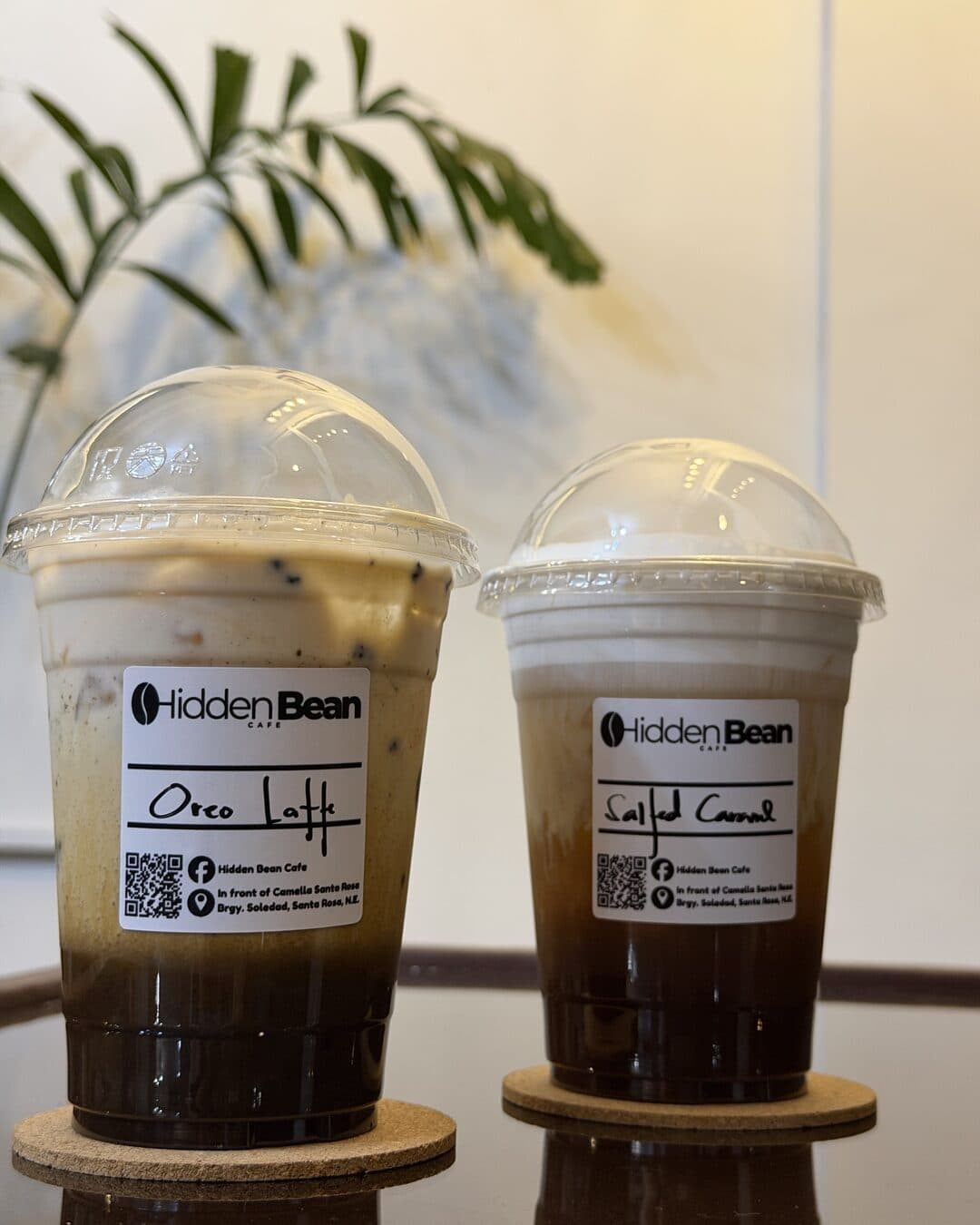Two iced coffees in branded Hidden Bean cups