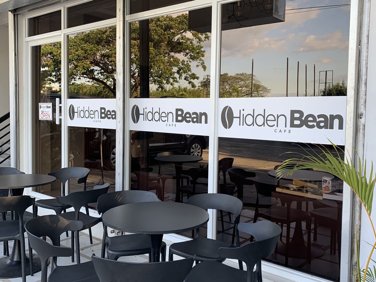 The glass frontage and outdoor seating at Hidden Bean Cafe